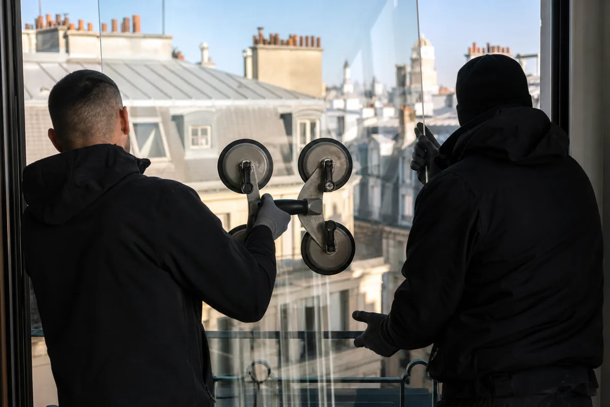 Pose d&rsquo;un panneau de verre sur mesure à la ventouse devant une terrasse d&rsquo;immeuble parisien